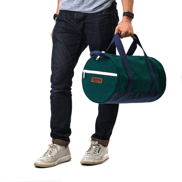 A person holding a round green duffel bag with navy handles.